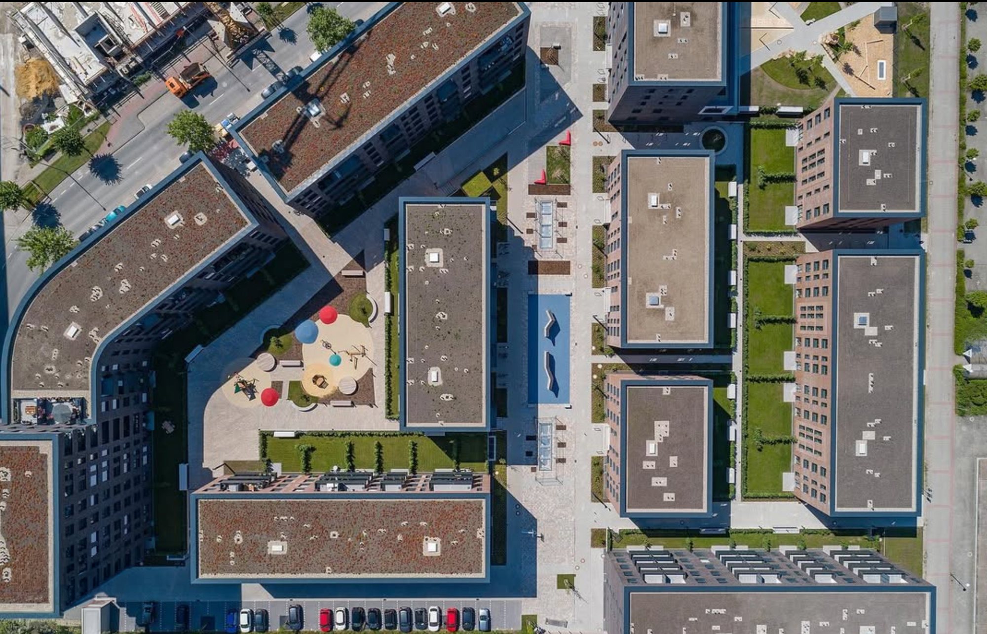 Senkrechte Drohnenaufnahme eines Wohnquartiers mit Flachdächern, Gründächern und Innenhöfen