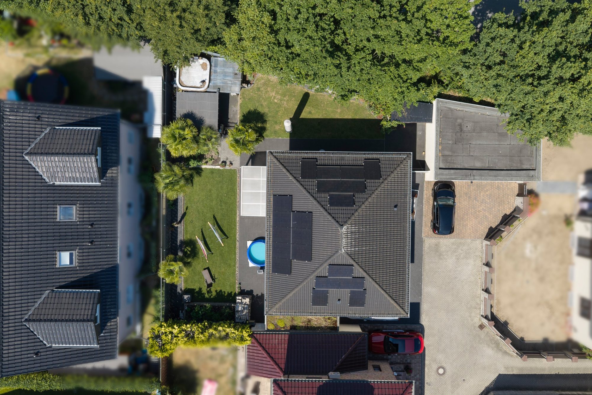 Senkrechte Drohnenaufnahme eines Einfamilienhauses mit Walmdach und Photovoltaik-Modulen